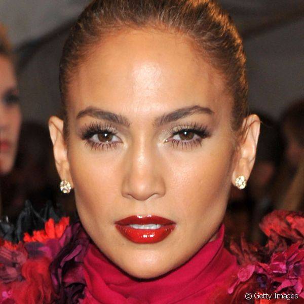 Em um evento de moda em Nova York, o batom vermelho com efeito de verniz deixou os lábios de Jennifer Lopez mais volumosos (Foto: Getty Images)
